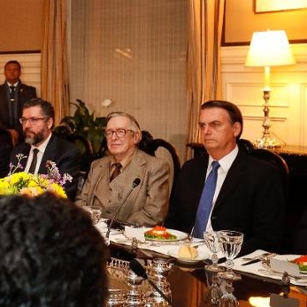 Ao lado de Olavo de Carvalho, presidente Jair Bolsonaro acompanha o discurso do embaixador brasileiro nos EUA, Sérgio Amaral